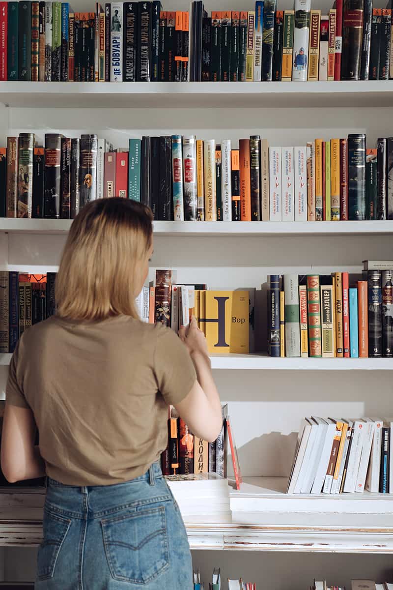 Frau am Bücherregal